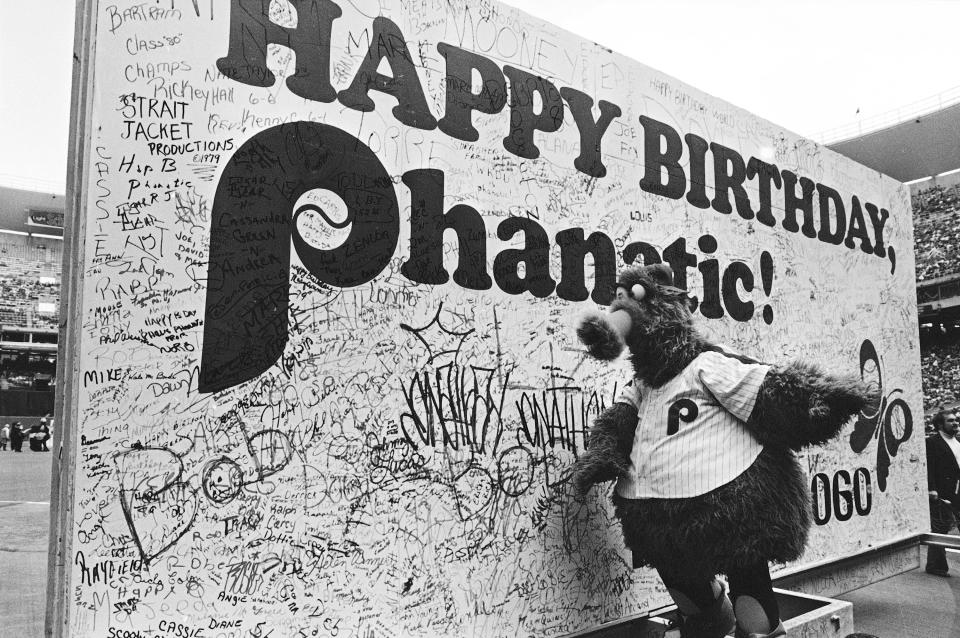 The Phillies mascot, the Philly Phanatic, admires a huge birthday card signed by thousands of his fans during pre-game ceremonies before the game against the San Diego Padres in Philadelphia, April 30, 1979. The Phanatic is played by Dave Raymond.