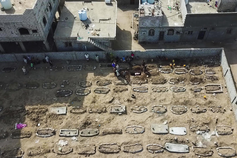 In this May 21, 2020, photo, grave diggers bury bodies at Radwan Cemetery in Aden, Yemen. At the cemetery in Yemen’s largest southern city, dozens of fresh graves are a testament to a spike in deaths amid the coronavirus pandemic. The cemetery workers who bury them don’t know what killed the newly deceased. But there’s no denying that there's been an increasing number of people getting sick in the port city of Aden — likely from the coronavirus. (AP Photo)