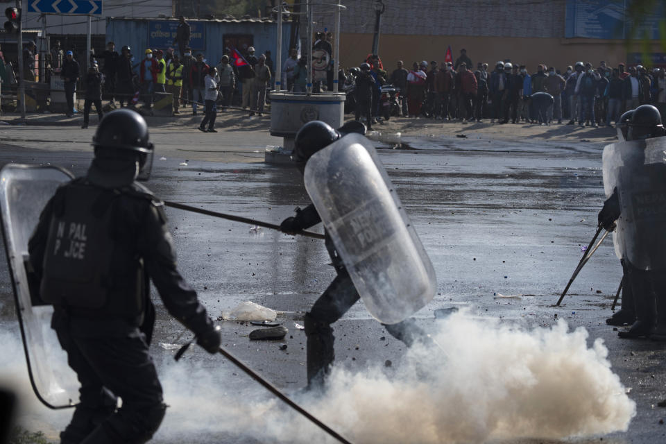 Protesters clash with police during a rally demanding a restoration of Nepal's monarchy in Kathmandu, Nepal, Thursday, Nov. 23, 2023. Riot police used batons and tear gas to halt tens of thousands of supporters of Nepal's former king demanding the restoration of the monarchy and the nation's former status as a Hindu state. Weeks of street protests in 2006 forced then King Gyanendra to abandon his authoritarian rule and introduce democracy. (AP Photo/Niranjan Shrestha)