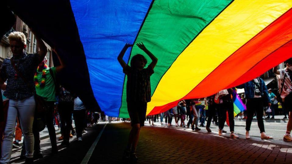 Un niño sujeta la bandera LGTBQ