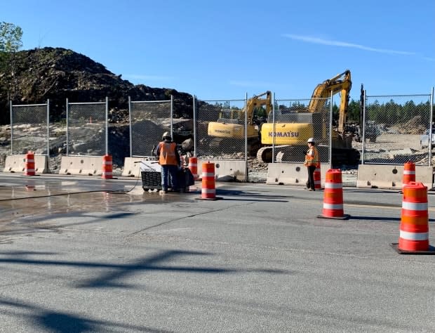 A worker uses a saw to cut up the pavement on Larry Uteck Boulevard on Monday as work on a new roundabout began. (Paul Palmeter/CBC - image credit)