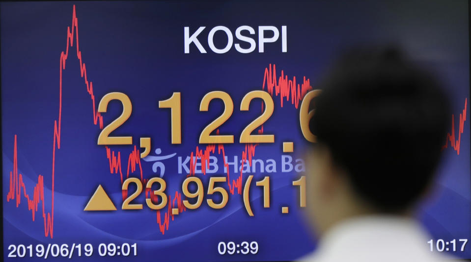 A currency trader walks by the screen showing the Korea Composite Stock Price Index (KOSPI) at the foreign exchange dealing room in Seoul, South Korea, Wednesday, June 19, 2019. Asian shares were mostly higher Wednesday on optimism about trade after President Donald Trump said he will talk with the Chinese leader later this month in Japan.(AP Photo/Lee Jin-man)