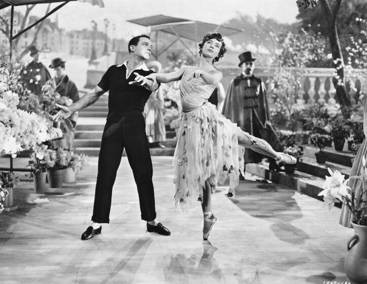 Gene Kelly and Leslie Caron dance in a black and white image from An American in Paris.