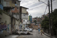 A car that was burned overnight sits charred in the Pavao Pavaozinho slum of Rio de Janeiro, Brazil, Wednesday, April 23, 2014. On Tuesday night, angry residents blaming police for the death of Douglas Rafael da Silva Pereira set fires and showered homemade explosives and glass bottles onto a busy avenue in the city's main tourist zone following the killing of the popular local figure. (AP Photo/Felipe Dana)