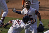 Houston Astros' Jose Altuve, top, is congratulated by Alex Bregman after hitting a two-run home run against the Oakland Athletics during the seventh inning of Game 4 of a baseball American League Division Series in Los Angeles, Thursday, Oct. 8, 2020. (AP Photo/Ashley Landis)