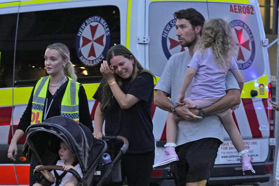 People are led out from the Westfield Shopping Centre where multiple people were stabbed in Sydney, Saturday, April 13, 2024. The Sydney Morning Herald reported that four people died in the stabbing. Police couldn't be immediately reached to confirm the report. The newspaper said one person was also shot, but it wasn't clear if the person had died.(AP Photo/Rick Rycroft)