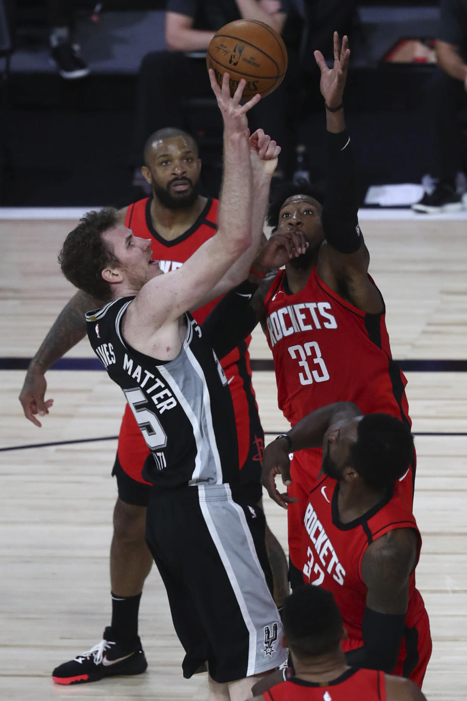 San Antonio Spurs center Jakob Poeltl (25) shoots while Houston Rockets forward Robert Covington (33) defends during the second half of an NBA basketball game Tuesday, Aug. 11, 2020, in Lake Buena Vista, Fla. (Kim Klement/Pool Photo via AP)