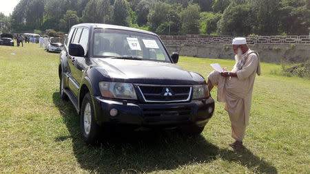 A man writes down the details of a government owned car on sale during an auction at the premises of Prime Minister's House in Islamabad, Pakistan September 17, 2018. REUTERS/Faisal Mahmood