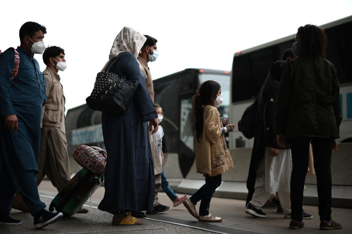 Refugees walk to board a bus at Dulles International Airport after being evacuated from Kabul following the Taliban takeover of Afghanistan on August 31, 2021 in Dulles, Virginia. (Anna Moneymaker/Getty Images)