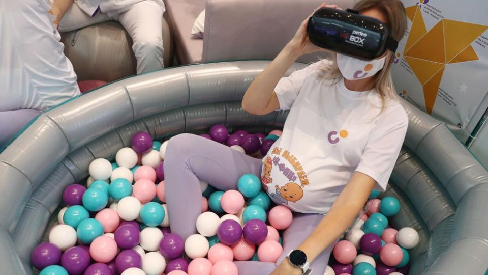 Una mujer embarazada con unas gafas de realidad virtual.