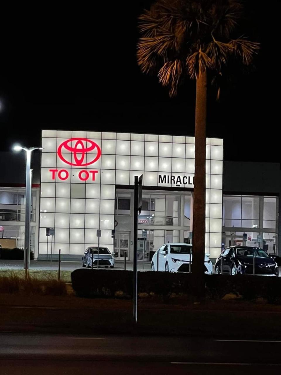Toyota dealership sign with burnt out letters that spell "Toot"