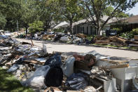 FILE - In this Sept. 7, 2017, file photo, flood damaged debris from homes lines the street in the aftermath of Hurricane Harvey in Houston. While it could take a decade to fully recover from Harvey, which came ashore Aug. 25, 2017, as a Category 4 storm, officials say Texas has already made great strides. However, they acknowledge that federal recovery funding has been slow in coming for some residents and that many are feeling frustrated and forgotten. (AP Photo/Matt Rourke, File)