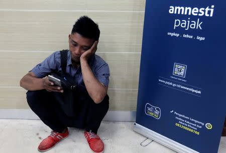 A man waits to register for the government's tax amnesty programme at a branch of the tax office in Jakarta, Indonesia September 30, 2016. REUTERS/Iqro Rinaldi