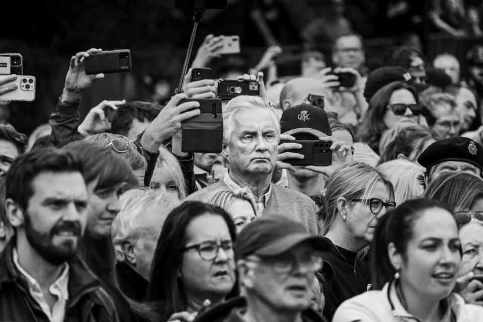 A man watches a procession bearing the coffin of Queen Elizabeth II.