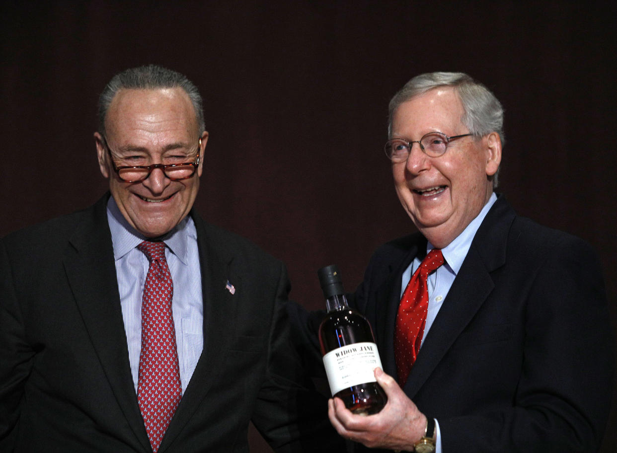 Chuck Schumer (left) (D-NY), presents Mitch McConnell (right) (R-KY) with a bottle of bourbon at the University of Louisville’s McConnell Center. (Bill Pugliano/Getty Images)