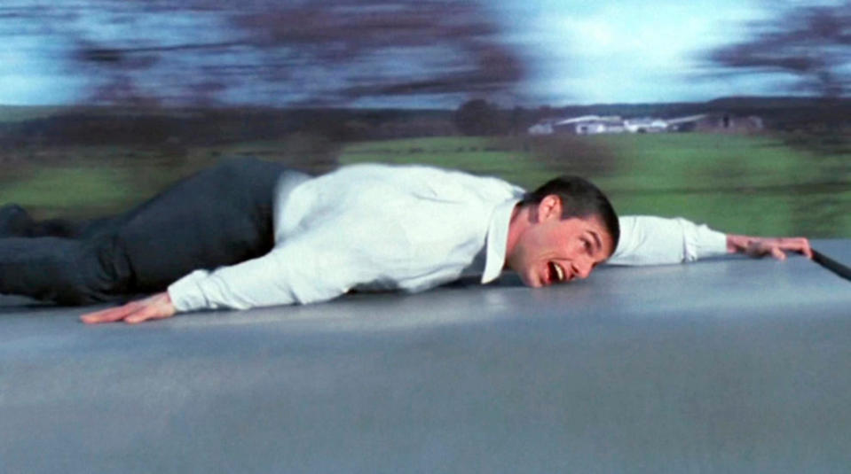 Том Круз в роли Итана Ханта, висящий за одну руку в поезде в фильме «Миссия невыполнима»