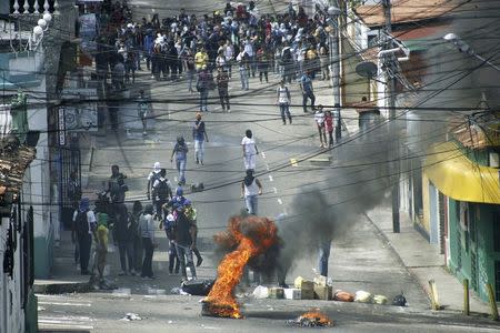 Students block a street as they clash with national guards during a protest against the government in San Cristobal January 14, 2015. REUTERS/Carlos Eduardo Ramirez