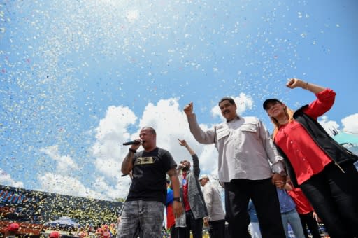 Venezuelan President and presidential candidate Nicolas Maduro (C) and his wife Cilia Flores (R) attend a rally ahead of Sunday's controversial elections