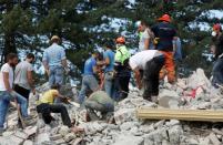 Socorristas ayudan a buscar entre los escombros de un edificio derrumbado por el terremoto en Amatrice, centro de Italia. 24 de agosto de 2016. Un devastador terremoto sacudió el miércoles varias localidades del centro de Italia, dejando al menos 120 personas muertas, residentes atrapados bajo los escombros y un número indeterminado de desaparecidos. REUTERS/Ciro De Luca