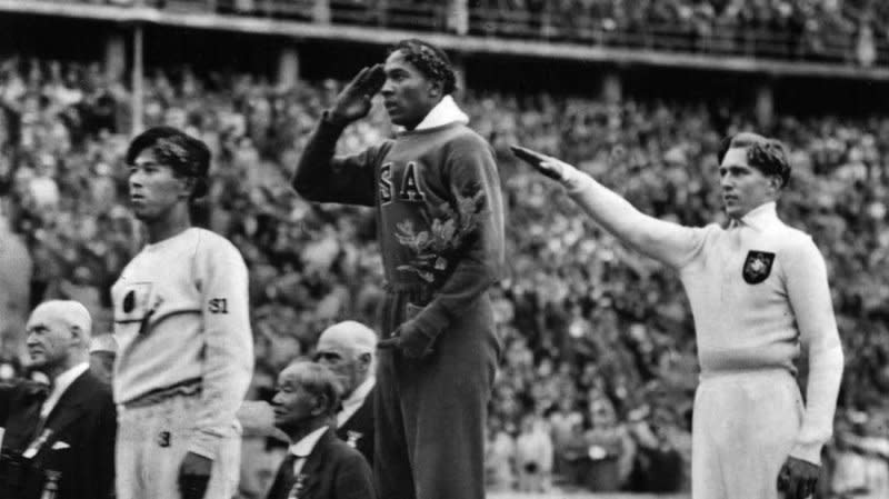 Jesse Owens, 22, wins a gold metal at the 1936 Berlin Olympics. Next to him, Germany's Luz Long gives the Nazi salute. Photo by UPI