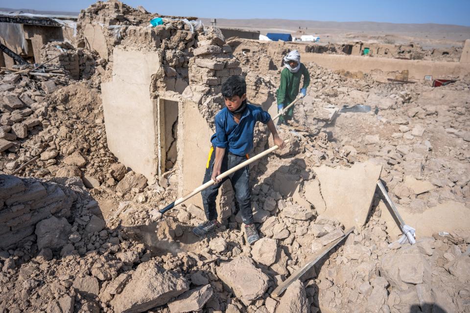 Thirteen-year-old Unse digs for pots of flour buried under what was his kitchen in San Job village, Zidan Jan District, western Afghanistan.