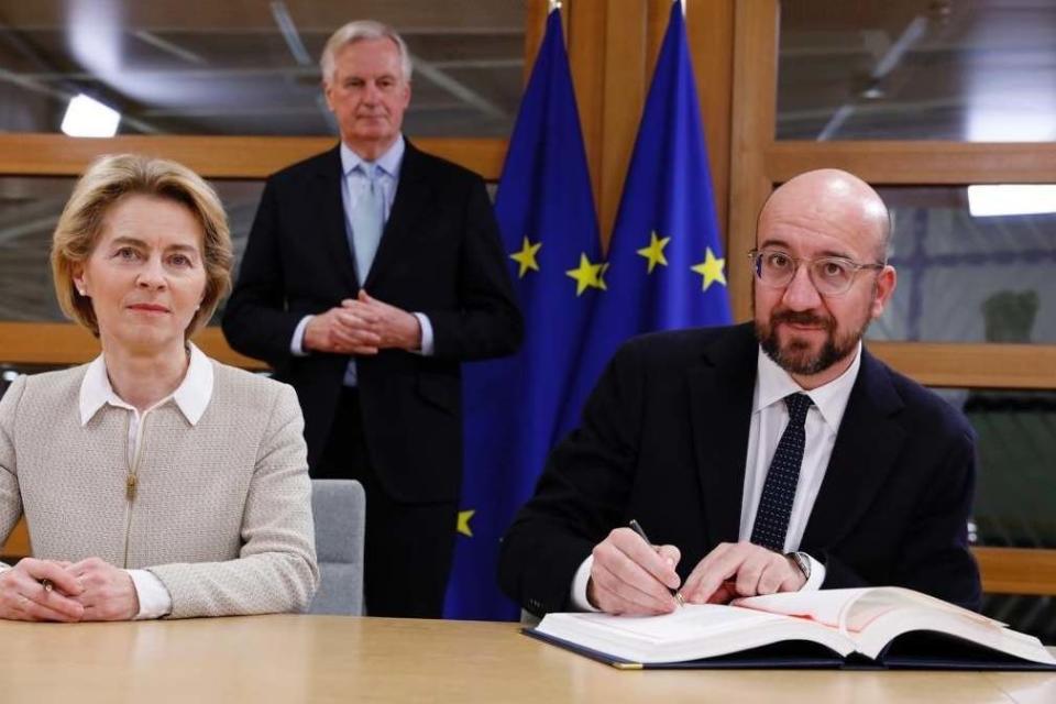 President of the European Council Charles Michel and European Commission President Ursula von der Leyen sign the withdrawal agreement as EU Chief Brexit Negotiator Michel Barnier looks on (PA)