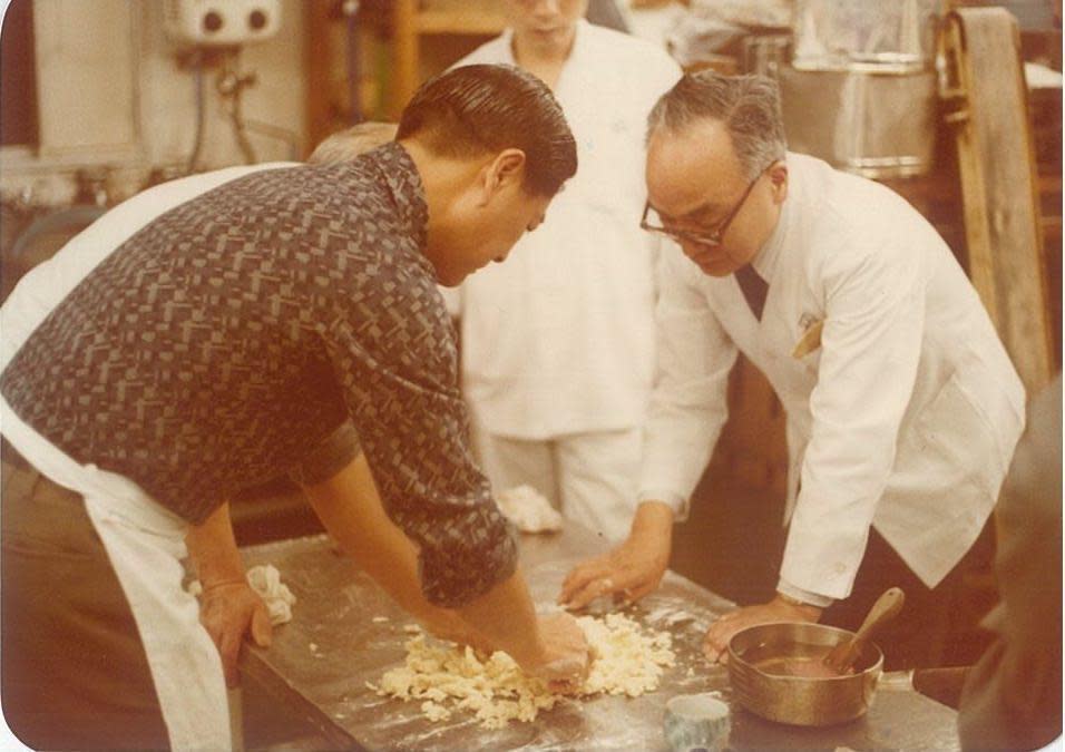 1980年，日本天皇御廚板垣正二（右）到不二家擔任顧問，教導製作蜜紅豆等日式技藝。（不二緻果提供）