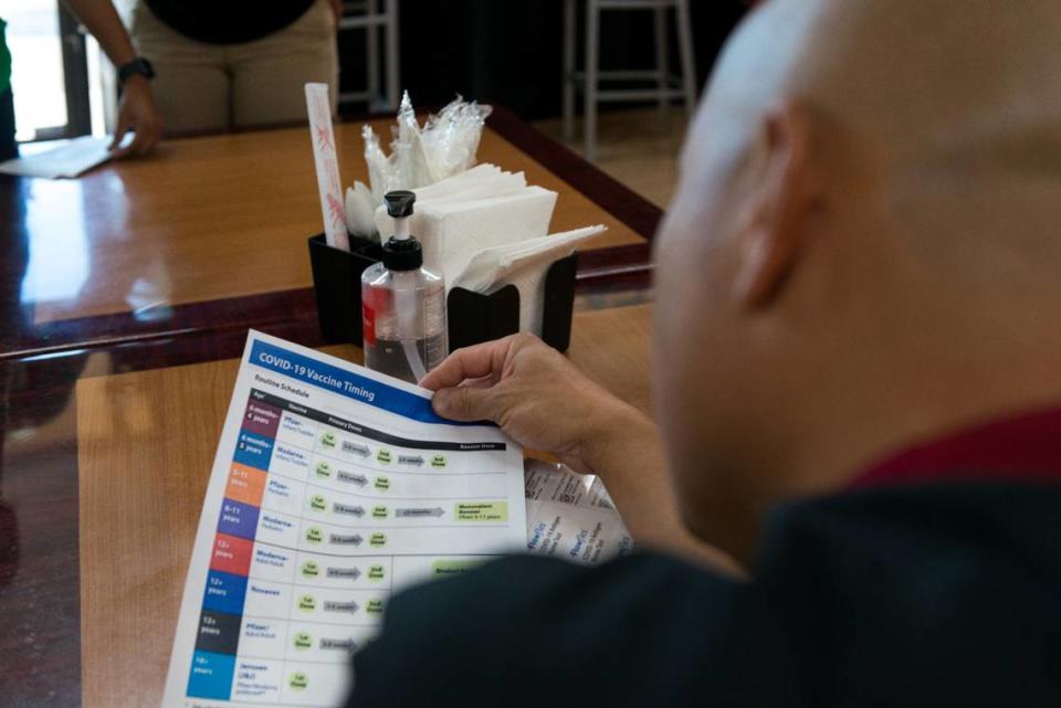 Jóvenes entregan pruebas de covid y folletos informativos a Chris Vang, propietario de Tiger Bite Bowls, un restaurante de fusión asiática en Fresno, California. Los jóvenes han sido capacitados como educadores de salud para promover las vacunas covid. Foto Heidi de Marco/KHN/(Heidi de Marco/KHN)