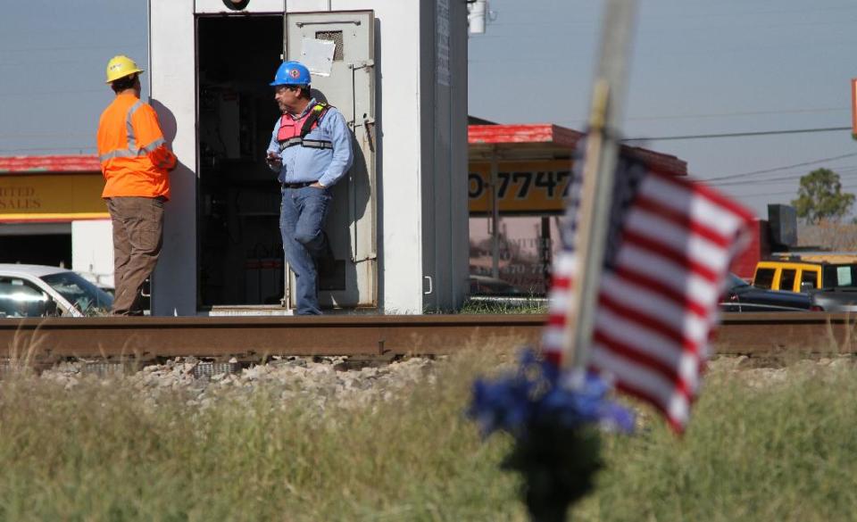 Railroad investigators work the scene of an accident where four veterans were killed and 16 other people were injured when a train slammed into a parade float carrying the returning heroes to a banquet last Thursday in Midland, Texas on Saturday, Nov. 17, 2012. Federal investigators were trying to determine whether the two-float parade had been given enough warning to clear the tracks. (AP Photo/Juan Carlos Llorca)