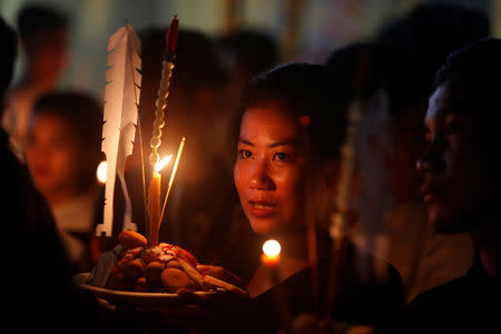 People hold offerings while praying for loved ones who have passed away during the first day of Pchum Ben festival, or the festival of the dead in Phnom Penh, Cambodia, September 25, 2018. REUTERS/Samrang Pring