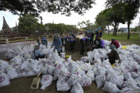 Soldiers fill sandbags for protect Wat Chaiwatthanaram in Ayutthaya province, north of Bangkok, Thailand, Monday, Sept. 27, 2021. Seasonal monsoon rains may worsen flooding that has already badly affected about a third of Thailand, officials said Monday as flood gates and pumping stations were being used to mitigate the potential damage. (AP Photo/Sakchai Lalit)