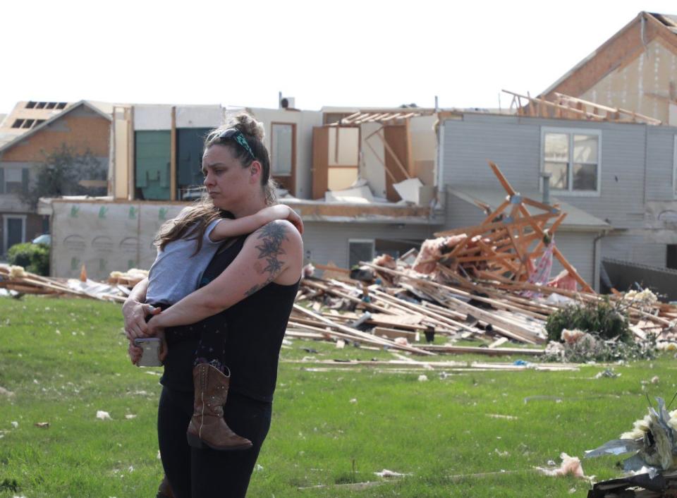 Meghan Porter and daughter Gemma,6, of Beavercreek stand in front of a damaged apartment complex. Porter said her childhood home in Beavercreek was destroyed. (WHIO File)