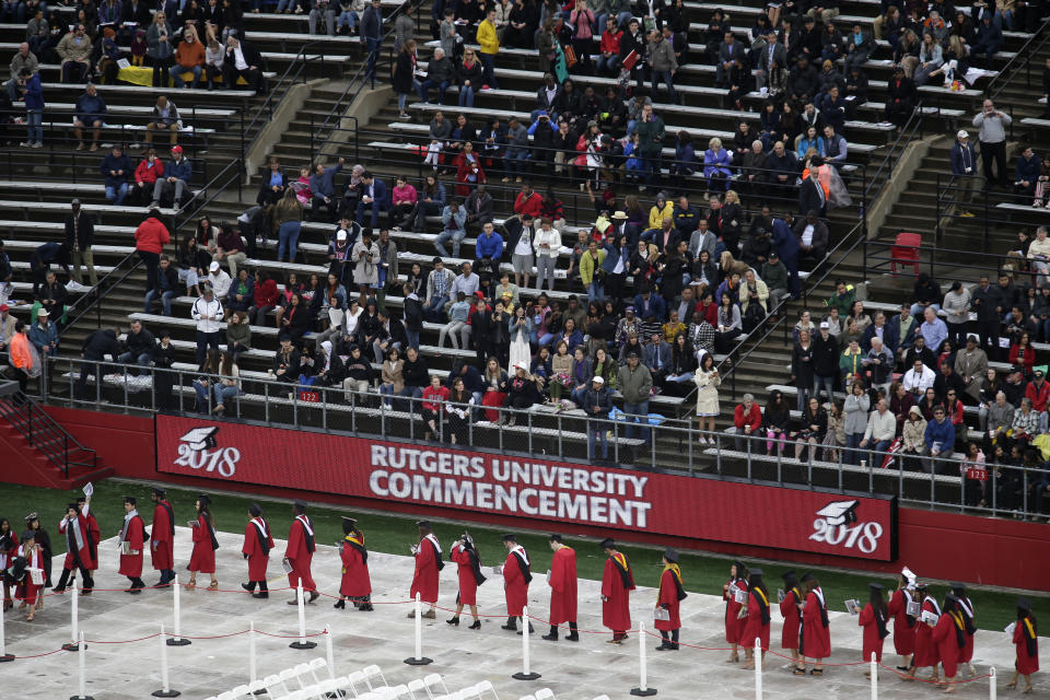 FILE - In this May 13, 2018, file photo, new graduates walk into the High Point Solutions Stadium before the start of the Rutgers University graduation ceremony in Piscataway Township, N.J. A growing number of colleges and universities are postponing tuition deadlines, waiving late fees and providing emergency grants to students whose finances have been tied up by the longest government shutdown in history. Among the latest to advertise help are Brown University, Rutgers University and the State University of New York system. (AP Photo/Seth Wenig, File)