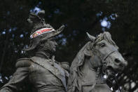 A campaign bandana of Free Party presidential candidate Xiomara Castro is seen placed on the statue of national hero Francisco Morazan after general elections in Tegucigalpa, Honduras, Monday, Nov. 29, 2021. Castro is holding a commanding lead as Hondurans appear poised to remove the conservative National Party after 12 years of continuous rule. (AP Photo/Moises Castillo)