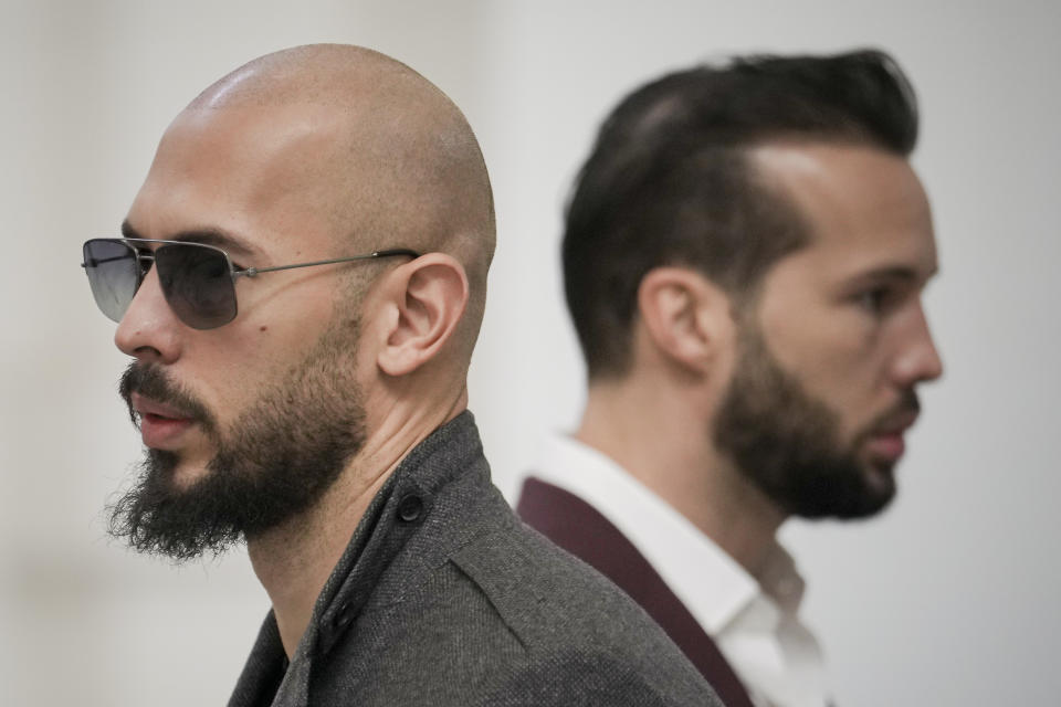 FILE - Andrew Tate, left, and his brother Tristan, right, wait inside the Court of Appeals building in Bucharest, Romania, Tuesday, Jan. 30, 2024. A court in Romania's capital on Friday, April 26, 2024, ruled that a trial can start in the case of influencer Andrew Tate, who is charged with human trafficking, rape and forming a criminal gang to sexually exploit women.(AP Photo/Vadim Ghirda, File)