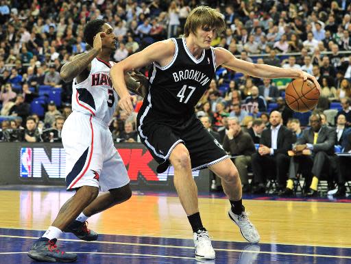 El jugador ruso de los Brooklyn Nets Andrei Kirilenko (D) intenta escapar de la presión de Louis Williams, de los Atlanta Hawks, en duelo de los Juegos Globales NBA Londres 2014, en el O2 Arena, en Londres, el 16 de enero de 2014. (AFP | Glyn Kirk)