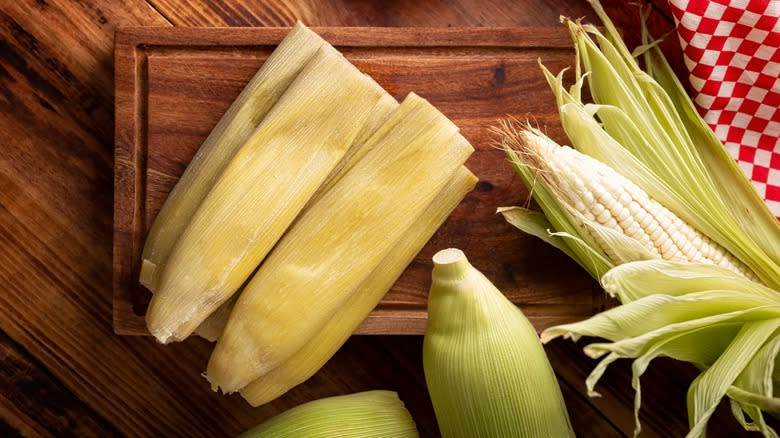 Corn and husks on cutting board