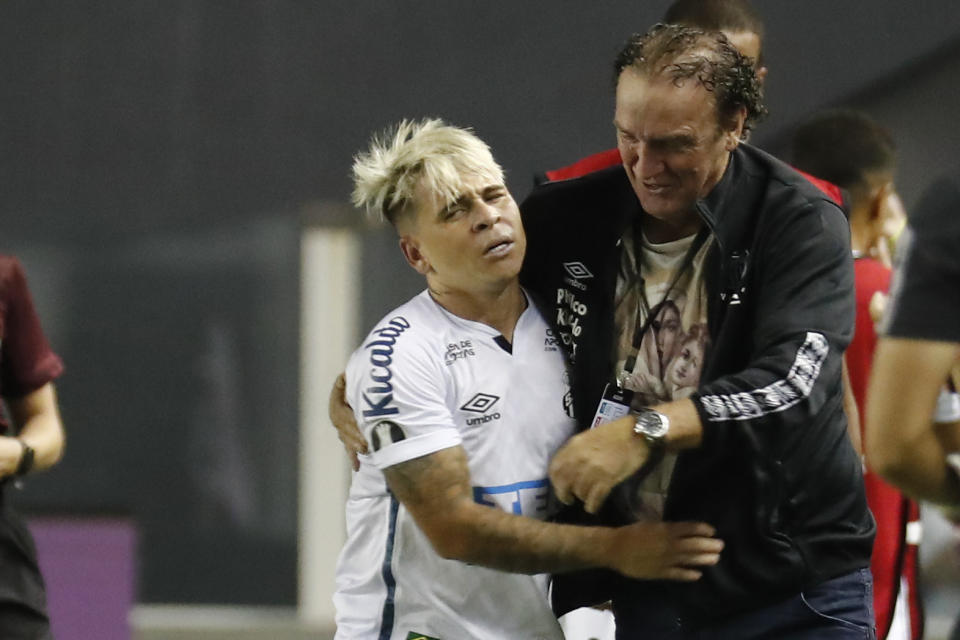 Cuca, el técnico de Santos, abraza al volante venezolano Yeferson Soteldo luego que éste anotó un gol ante Boca Juniors en las semifinales de la Copa Libertadores, en Santos, el miércoles 13 de enero de 2021. (Sebastiao Moreira/Pool vía AP)