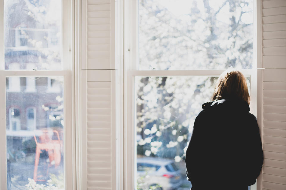 person looking at outside from indoors