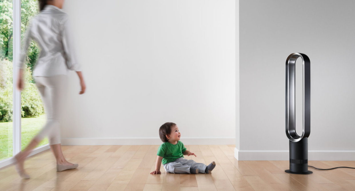 dyson tower fan from best buy buy canada with baby boy sitting in front and woman walking towards child