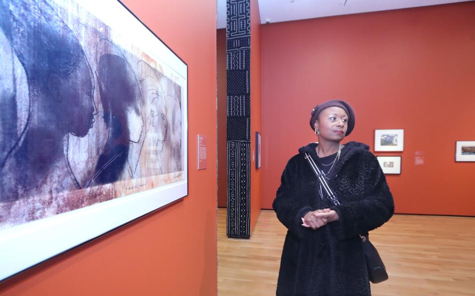 Tameka Ellington, guest curator of "RETOLD: African American Art and Folklore" at the Akron Art Museum, talks about the work of Kent State alum Curlee Raven Holton, "Bred for Pleasure," on Monday.