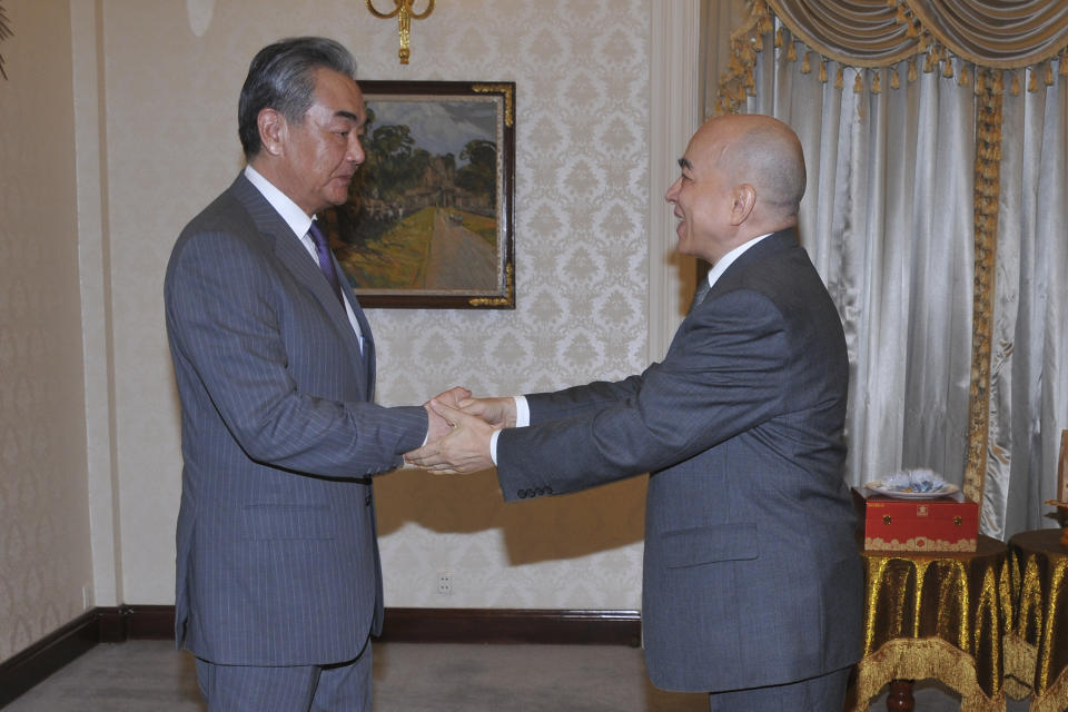 In this photo released by Agence Kampuchea Press (AKP), Chinese Foreign Minister Wang Yi, left, greets with Cambodia's King Norodom Sihamoni, right, in Royal Palace, in Phnom Penh, Cambodia, Sunday, April 21, 2024. Wang Yi, arrived Cambodia to mark his 3 days official visit (21-23 April) Cambodia to reaffirm his country's commitment and to boost the already firmly tied to southeast Asian country, twice visited in the last eight months. (AKP via AP)