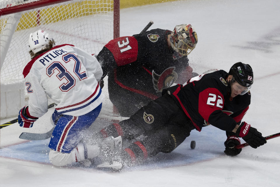 Ottawa Senators goaltender Anton Forsberg, center, watches for the puck as Senators defenseman Nikita Zaitsev, right, and Montreal Canadiens center Rem Pitlick slide into the crease during second-period NHL hockey game action Saturday, Jan. 28, 2023, in Ottawa, Ontario. (Adrian Wyld/The Canadian Press via AP)