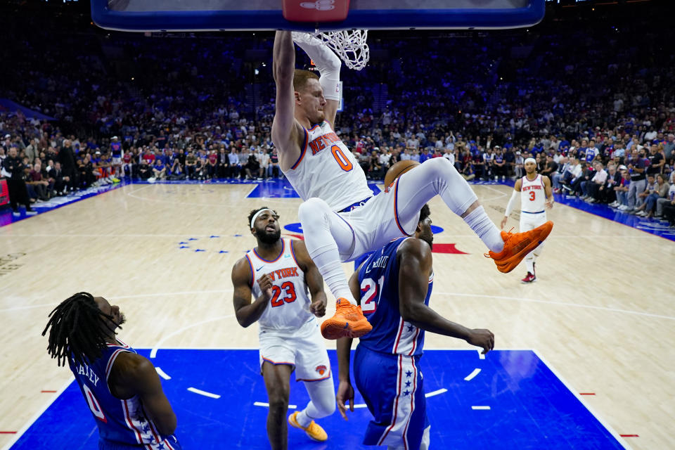 New York Knicks' Donte DiVincenzo (0) dunks past Philadelphia 76ers' Tyrese Maxey (0) and Joel Embiid (21) as Mitchell Robinson looks on during the second half of Game 6 in an NBA basketball first-round playoff series, Thursday, May 2, 2024, in Philadelphia. (AP Photo/Matt Slocum)