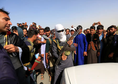 A Taliban (C) stands celebrates ceasefire with people in Rodat district of Nangarhar province, Afghanistan June 16, 2018.REUTERS/Parwiz