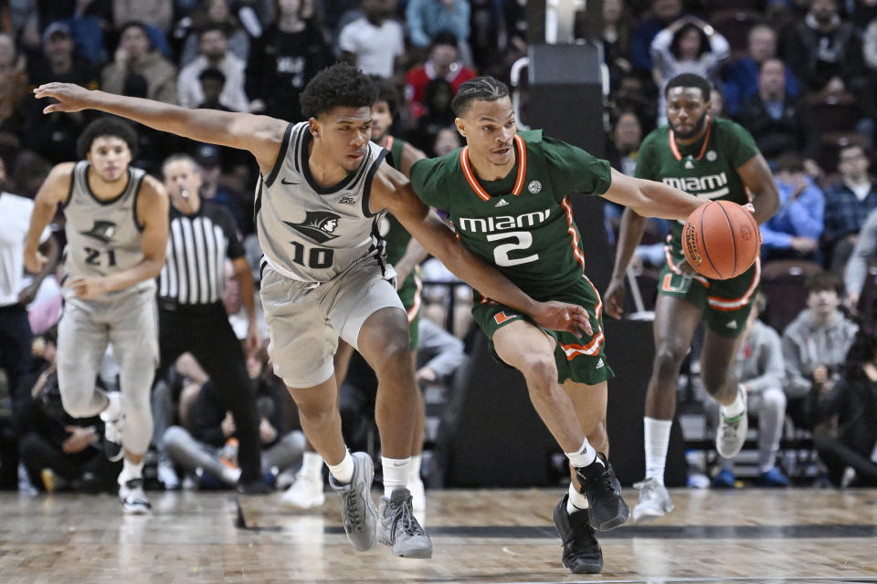 Miami guard Isaiah Wong (2) steals the ball from Providence guard Noah Locke (10) in the second half of an NCAA college basketball game, Saturday, Nov. 19, 2022, in Uncasville, Conn. (AP Photo/Jessica Hill)