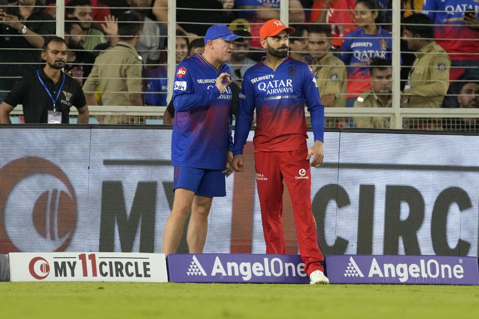 Royal Challengers Bengaluru's Virat Kohli, listens to team coach Andy Flower during the Indian Premier League eliminator cricket match between Royal Challengers Bengaluru and Rajasthan Royals in Ahmedabad, India, Wednesday, May 22, 2024. (AP Photo/Ajit Solanki)