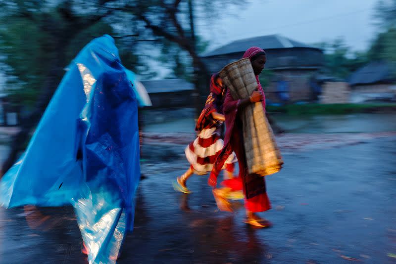 People move with their belongings to the cyclone shelter before Cyclone Remal in Satkhira