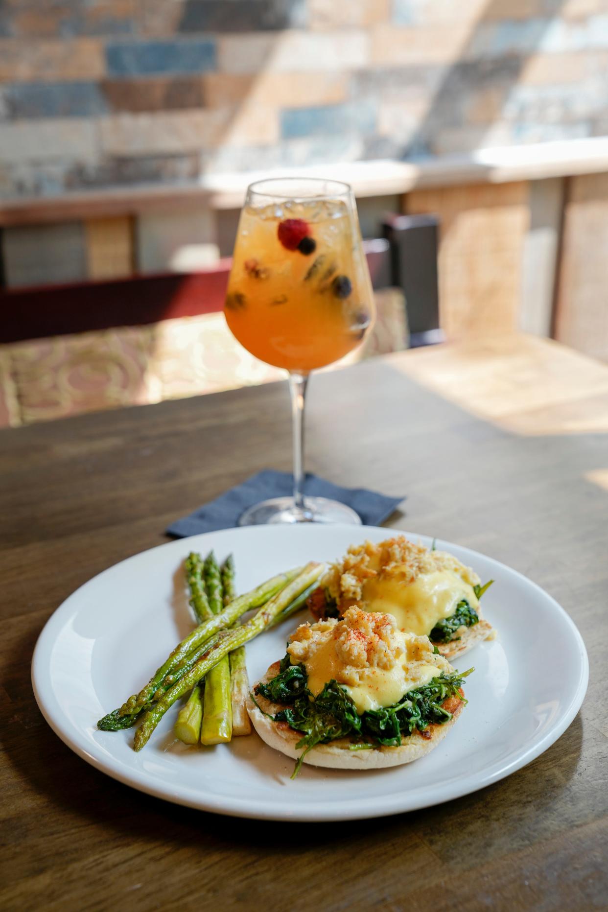 Crab Benedict, featuring blue crab and poached eggs on a bed of spinach, served atop an English muffin and accompanied by sangria at Fado Pub & Kitchen in Dublin's Bridge Park.