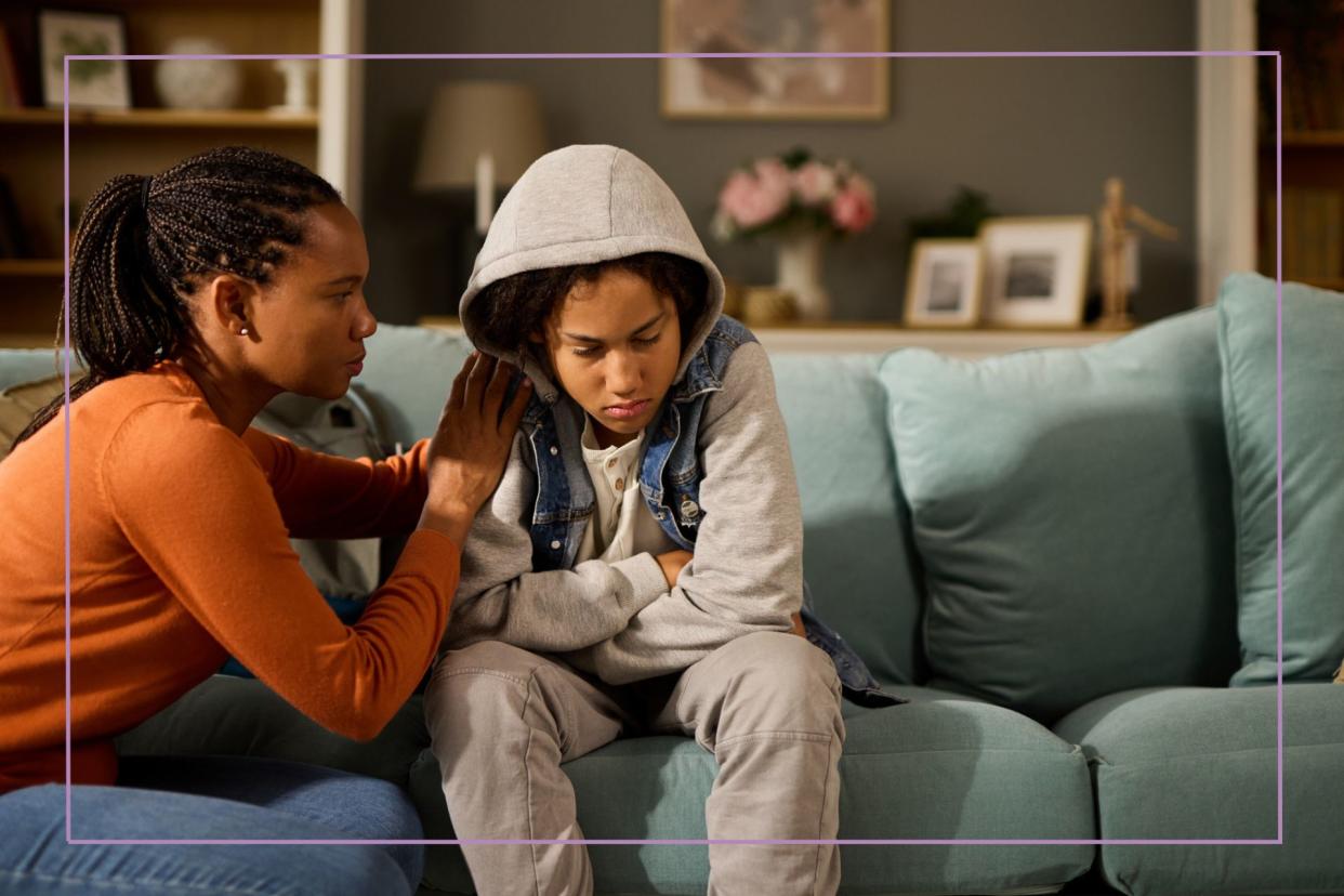  Mother comforting her son at home- teenage problems. 